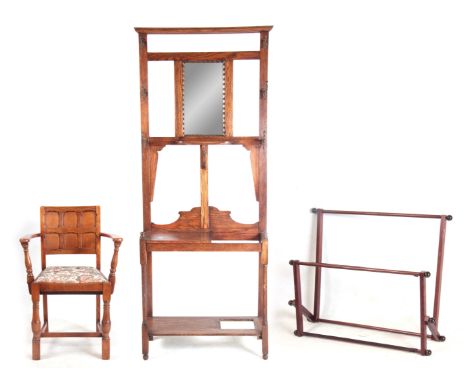 A OAK HALLSTAND with mirrored back, coat hooks and umbrella stand 74cm wide 191cm high. PLUS AN OAK PANELLED ARMCHAIR AND TAP