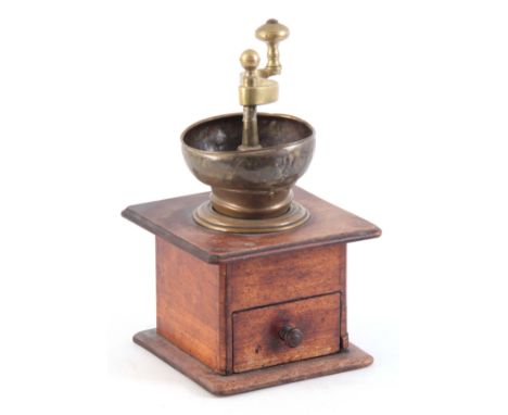 AN 18TH CENTURY BRASS AND WALNUT COFFEE GRINDER with cast shaped handle and bowl mounted on a walnut base with drawer 30cm hi