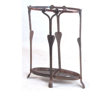 A LATE 19TH CENTURY ARTS AND CRAFTS UMBRELLA/STICK STAND circa 1890 of wrought iron and copper construction having cast iron 