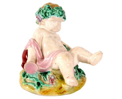 A 19th Century Worcester Polychrome FIGURE of a reclining Putti 8cm high
