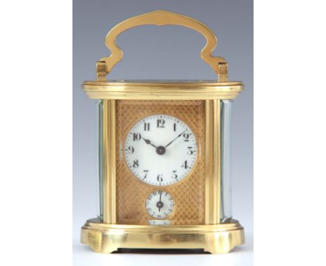 AN EARLY 20th CENTURY FRENCH OVAL CASED CARRIAGE CLOCK the brass case enclosing a 4.5cm engine turned gilt masked porcelain d