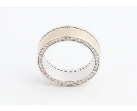 A diamond set wedding band, channel set with round brilliant cut diamonds to top of band and around the edge of one side, whi