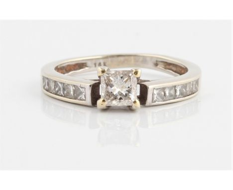 A diamond ring, set with a principal princess cut diamond, measuring approx. 0.40ct, with further princess cut diamonds chann
