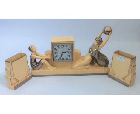 An Odyv Art Deco mantel clock with girls playing catch, height 25cm, together with two matching garnitures. IMPORTANT: Online