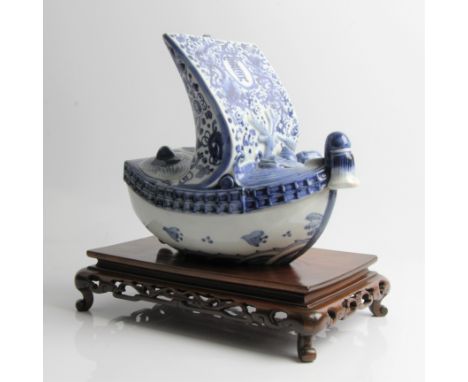 A Chinese blue and white ceramic sailing ship in two parts, decorated with dragons and character mark, on wooden base, approx