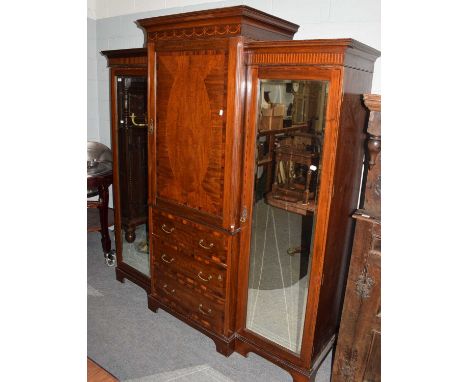 An Edwardian Maple &amp; Co inlaid and crossbanded mahogany breakfront twin mirror triple wardrobe, the central cupboard door