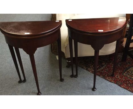 Two 19th century mahogany fold-over demi lune occasional tables of small proportions, raised on slender plain turned supports