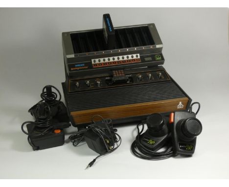 An Atari CX2600 'light sixer' (cx-2600U), with AV and power cable, a pair of joysticks and paddle controllers, also including