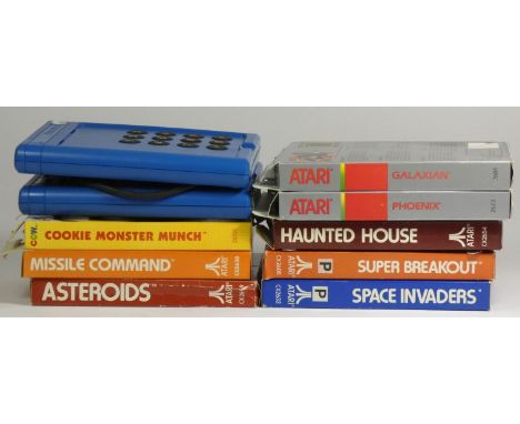 Eight Atari 2600 games, including Cookie Monster Munch (original box, card insert, manual and Kids Controllers), Missile Comm