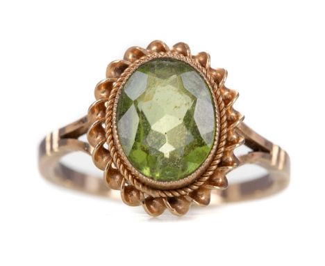 PERIDOT RING,the oval faceted gem, within a ropetwist border, in nine carat gold, size K, 2.5g
