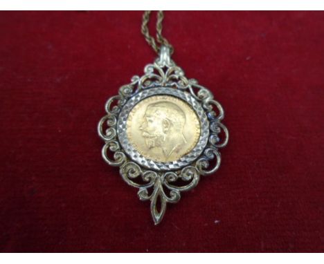 A George V half sovereign 1913, set in a hallmarked 9ct gold pendant. With chain (clasp broken) 15g total weight