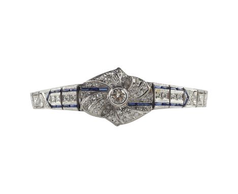 One women's platinum, diamond, and sapphire bracelet. The bracelet is bezel set with one 5.2 mm round brilliant cut diamond, 