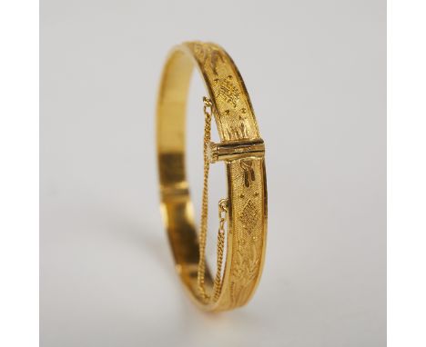 Chinese 22K yellow gold bangle bracelet decorated with a dragon chasing a pearl on one side and a phoenix along the the other