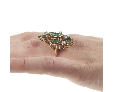 One women's eighteen karat yellow gold emerald and diamond fashion ring. The ring is prong set with one marquise shaped emera