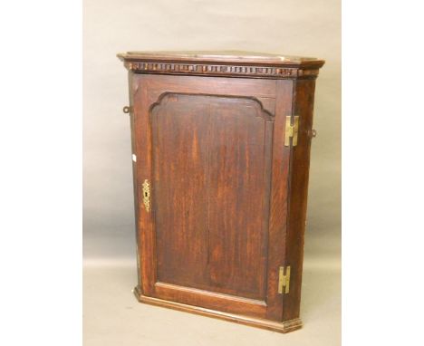 A C19th oak hanging corner cupboard with dentil cornice and shaped shelf interior, 28'' x 14'' x 38'' 