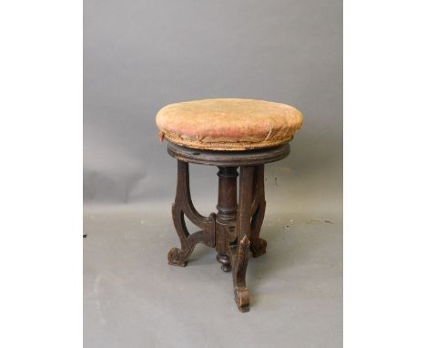 A Victorian walnut revolving piano stool on pierced supports with scrolled ends, 19½'' high 