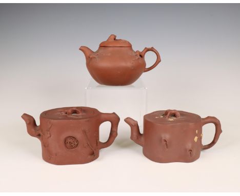China, three Yixing teapots and covers, 19th/ 20th century, two shaped as a gnarled tree-trunk, each applied with prunus bran