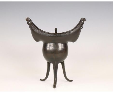 China, a bronze tripod ritual wine vessel, yue, Yuan or early Ming dynasty, 14th/ 15th century, cast in a boat shape, the twi