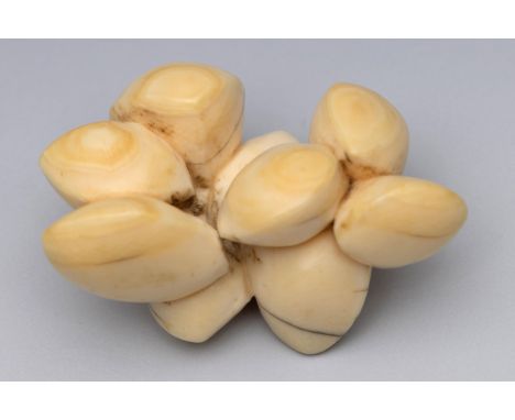 Japan, an ivory netsuke, Edo period (1603-1868), 19th century, carved as nine icho nuts with natural himotoshi (natural crack