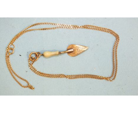 A miniature trowel pendant on a 9ct gold curb-link chain, (chain 2.2g).
