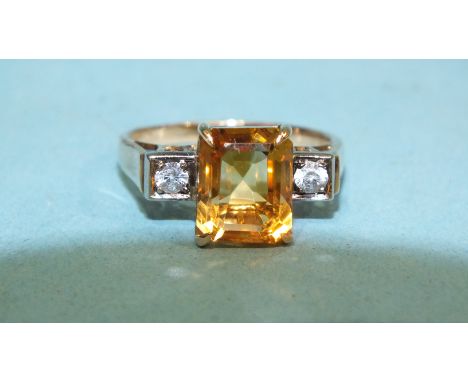 A 9ct yellow gold ring set a step-cut citrine, between two synthetic white sapphires, size R, 4.1g.