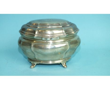 An Edwardian silver tea caddy in the Georgian style, of bombe form, on four scroll feet, by The Goldsmiths &amp; Silversmiths