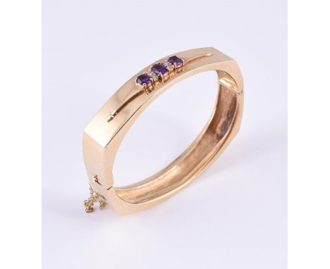 
	
		AN AMETHYST AND DIAMOND BANGLE
		The hinged bangle of squared oval outline, applied with a tapered motif set with three 