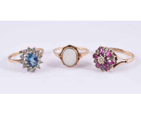 
	
		A COLLECTION OF THREE DRESS RINGS
		To include a blue topaz and diamond point cluster ring, London 1989; a ruby and diam