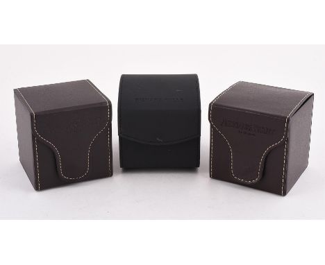 
	
		THREE WATCH BOXES
		To include: two Audemars Piguet brown leather cube boxes, opening to suede interiors with cushions, 