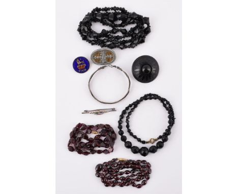 
	
		A GROUP OF JEWELLERY AND COSTUME JEWELLERY
		Comprising: a jet brooch; two garnet bead necklaces; two black paste bead n