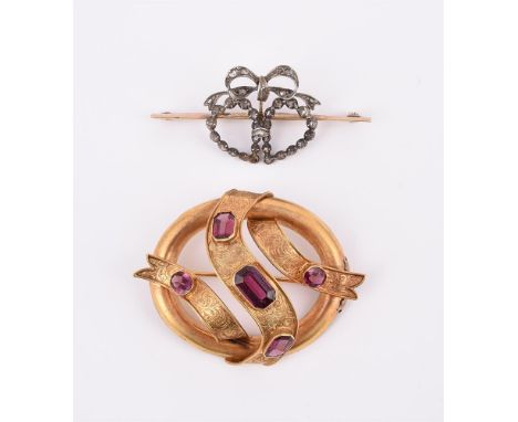 
	
		A MID VICTORIAN GARNET RIBBON BROOCH 
		The brooch designed as a hoop, with an engraved scrolled foliate ribbon with ste