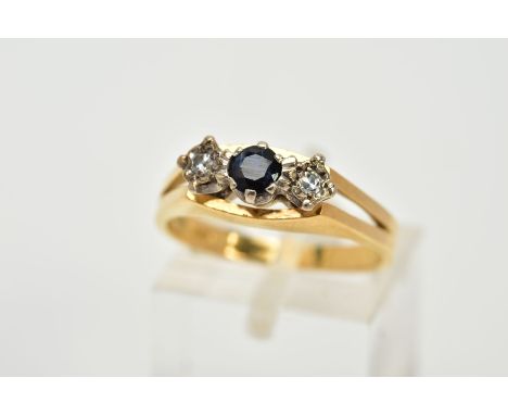 A YELLOW METAL THREE STONE SAPPHIRE AND DIAMOND RING, the raised designed set with a central circular cut sapphire flanked wi