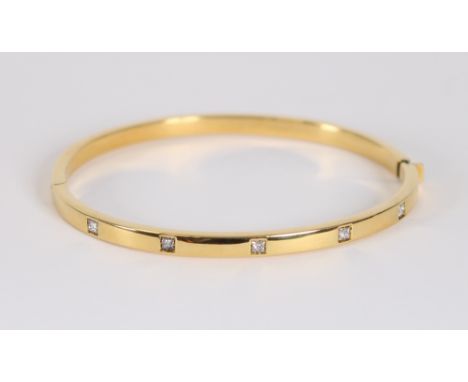 An 18 carat gold bangle, set with 5 Princess cut diamonds