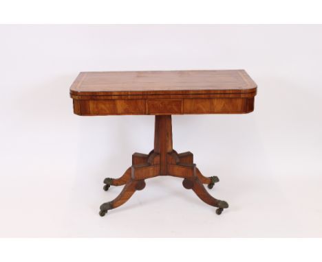 A Regency satin wood and cross banded card table, the fold over swivel top raised on an octagonal central column and quadrupl