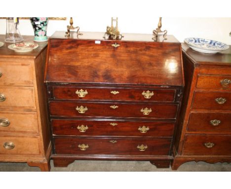 A Georgian mahogany bureau, the fall front opening to reveal an interior arrangement of drawers and pigeonholes, four long gr