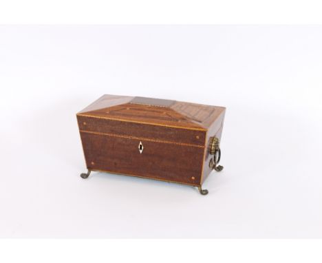 A Regency mahogany and satinwood strung three compartment tea caddy, of sarcophagus form flanked by lion mask brass ring hand