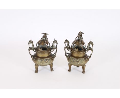 A pair of 19th Century Chinese bronze incense burners, the pierced covers with dog of fo finials above dragon handles and inc