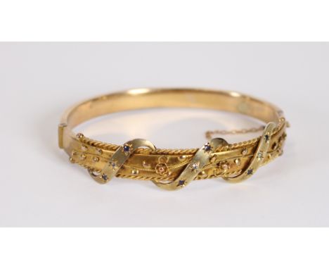 An Edwardian 9 carat gold bangle, set sapphires and diamonds