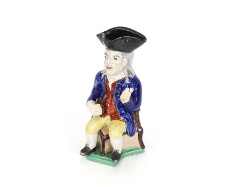 A Staffordshire jug, in the form of a seated Toby Philpott holding pipe and jug, 26cm high