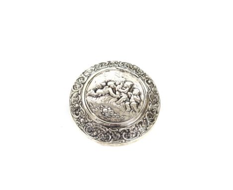 A continental white metal circular snuff box, the lid decorated with cherubs, the body with profuse foliate scrolls, 8.5cm di