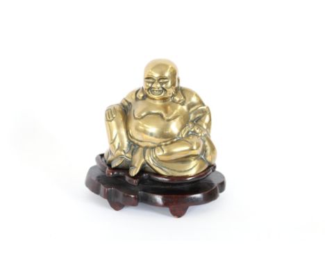 An early 20th Century polished bronze figure of Ho Tei,sitting on a hardwood base, 24cm high overall 