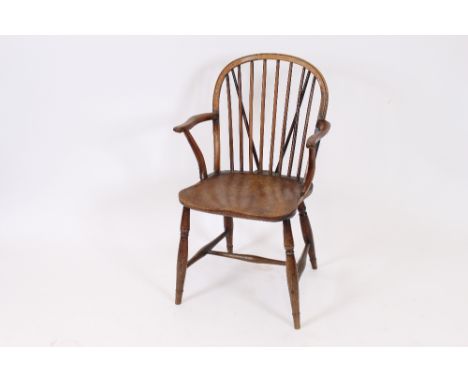 A 19th Century yew wood and elm stick back elbow chair, raised on turned supports united by an H stretcher