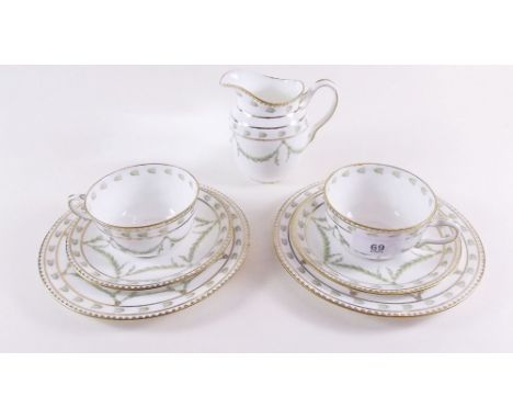 An Edwardian Wedgwood set of eleven tea cups and saucers and six tea plates decorated green swags, pattern number X4778