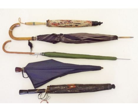 Three vintage umbrellas and two parasols