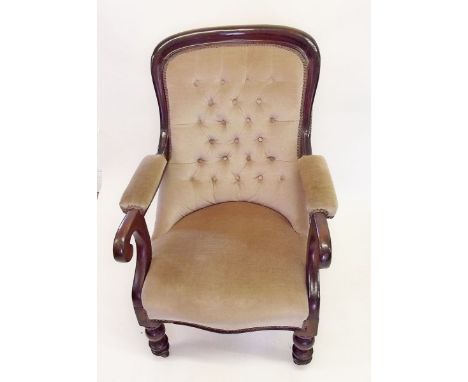 A Victorian armchair with button upholstered back and scrollover arms 