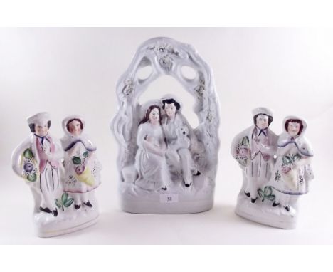 A Staffordshire bocage group 36cm high and pair of figures with flowers 23cm high