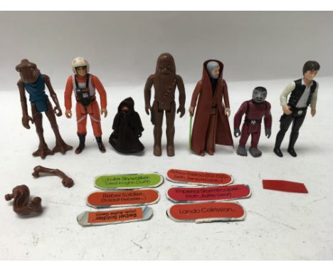 A collection of vintage Star Wars figures including Chewbacca, Han Solo (large head), Snaggletooth, a Jawa and Obi Wan Kenobi
