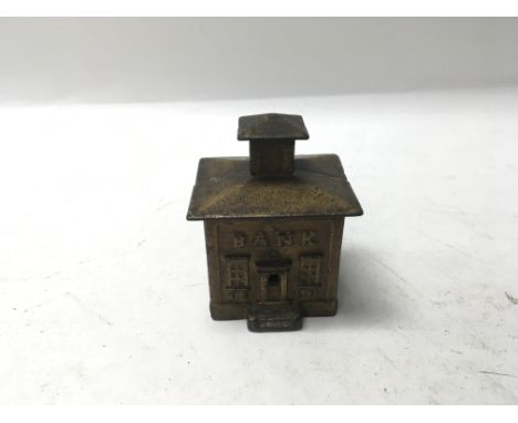 A small vintage gilded metal money box in the form of an American bank