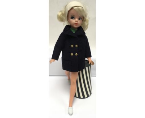 A vintage late 1960’s Sindy doll with twist waist, blonde hair and applied eyelashes. Wearing original labelled reefer jacket