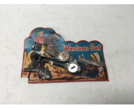 An original western set on card comprising of a watch on strap, compass on strap and a model pistol